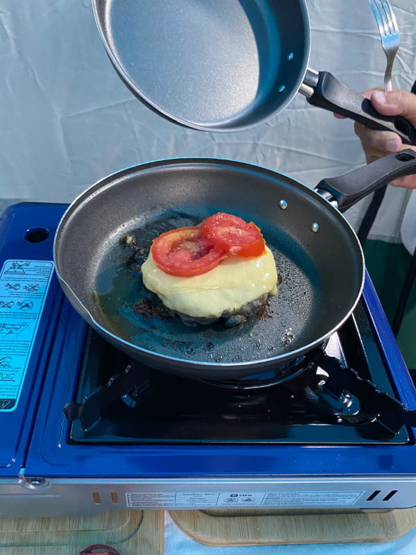 Dicas de cardápios para preparar no camping com fogareiro: hamburguer gourmet sendo preparado em um fogareiro da Nautika.