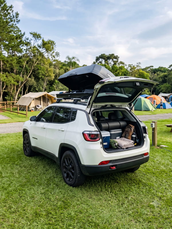 Bagageiro de teto do carro carregado com equipamentos de camping bem organizados e presos com segurança.