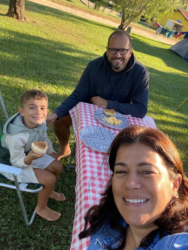 Quem somos: família Guia do Campista tomando café de manhã na grama do camping Fazenda Paineiras.