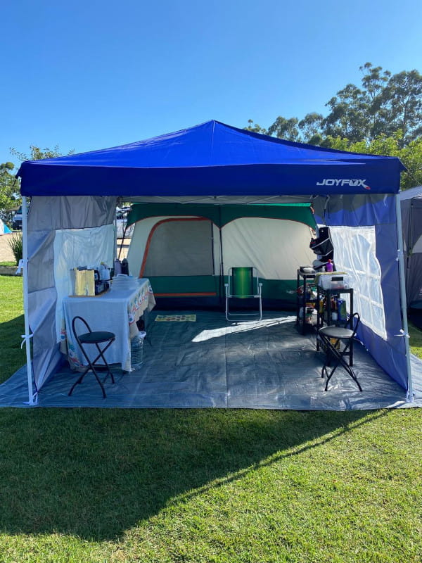 Por que usar uma ráfia de solo na estrutura de camping: barraca de camping e gazebo montados sobre uma ráfia de solo, com vários equipamentos de cozinha.
